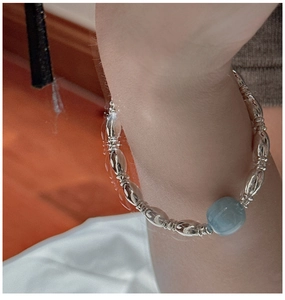 Macro view of S925 sterling silver beaded bracelet with a translucent light blue gemstone