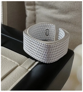Detail of adjustable S925 sterling silver square ring with woven chain texture