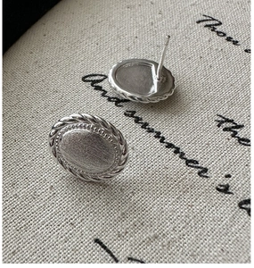 Macro detail of S925 sterling silver oval stud earrings with woven texture and matte finish