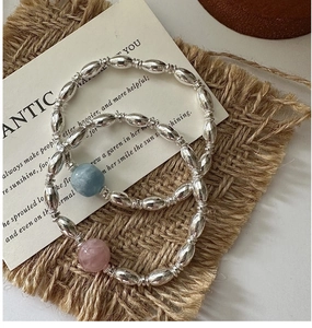 Detail of S925 sterling silver beaded bracelets with pink and blue natural stone charms