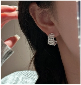 Detailed close-up of S925 silver woven mesh C-shape hoop earrings on model's ear