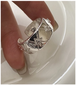 Close-up of S925 silver ring featuring carved star patterns and micro-set zircons