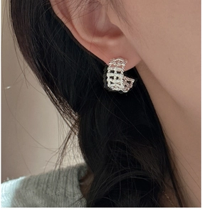 Close-up of S925 sterling silver woven mesh hoop earrings worn on a model's ear
