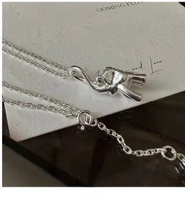 Macro shot of S925 sterling silver elephant pendant and fine chain on a vintage card