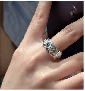 Macro shot of silver wide band ring featuring embossed stars and sparkling zirconia