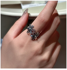 Detail shot of vintage silver double flower open ring on finger showing hollow petals