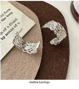 Close-up of S925 sterling silver hollow wave earrings with hallmark detail