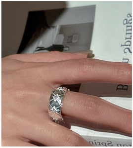 Macro shot of silver wide-band vintage star ring with sparkling zircon stone inlay