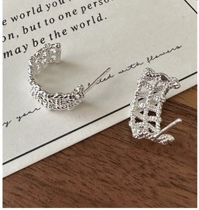 Macro detail of S925 sterling silver C-shape earrings with woven mesh texture design