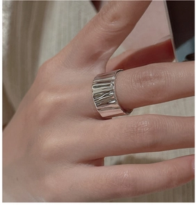 Detail of a minimalist S925 sterling silver wide ring with unique crumpled texture finish