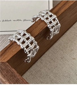 Detail shot of silver braided mesh hoop earrings with intricate woven texture finish