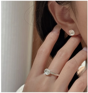 Detail of matte S925 silver earring and ring set with organic disk and zircon