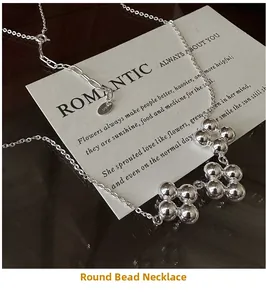 Gros plan d'un collier trèfle en argent sterling S925 sur une carte cadeau blanche