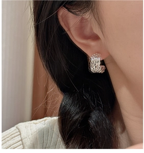 Macro side view of layered wave hollow hoop earrings in S925 silver on model