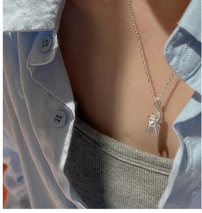 Detailed close-up of a 925 sterling silver vintage elephant pendant necklace on a model
