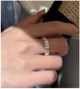 Macro detail of a 925 silver geometric textured ring with a round center crystal