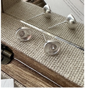Macro detail of S925 sterling silver earrings with hammered texture and zircon insets