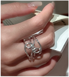 Detail of a wide multi-layered silver ring with flowing wave design on model hand