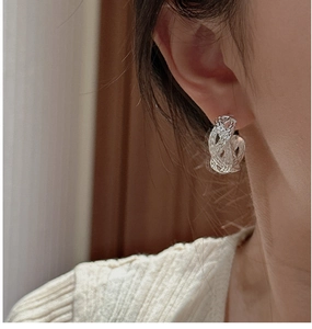 Detailed view of S925 sterling silver woven knot earrings on model for a chic retro look
