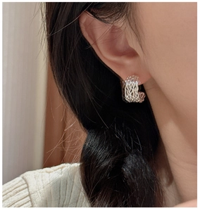 Close-up of S925 sterling silver triple-layered wavy hoop earrings worn by a model