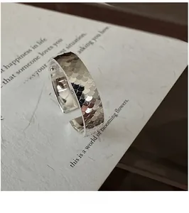 Détail macro d'une bague en argent S925 avec texture effet glace pilée sur carte blanche