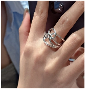 Detail of minimalist S925 sterling silver multilayer knotted ring on a finger