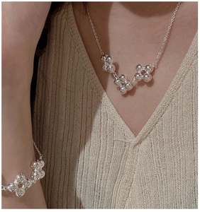 Détail macro d'un ensemble collier et bracelet en argent sterling S925 sur un modèle