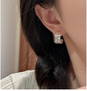 Close-up of S925 sterling silver triple-layered wavy hoop earrings on a model
