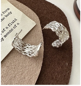Macro view of S925 sterling silver earrings with triple-layer hollow wave texture