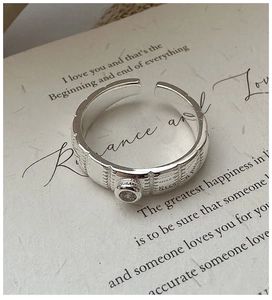 Detail view of silver open ring with vertical vintage texture and single zircon stone