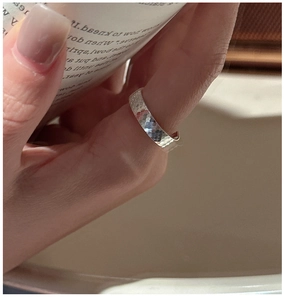 Gros plan d'une bague en argent S925 à texture martelée portée au doigt