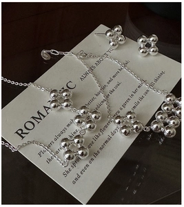 Macro shot of S925 sterling silver stamp on minimalist beaded flower jewelry set