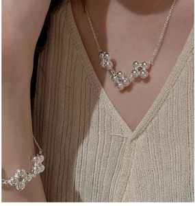 Détail de l'ensemble collier et bracelet à fleurs perlées en argent S925 sur modèle