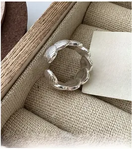 Close-up of S925 sterling silver shell ring in a wooden box with linen background
