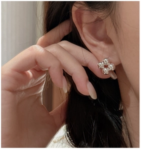 Close-up of a model wearing S925 sterling silver minimalist four-bead stud earrings