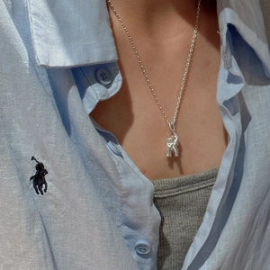 Minimalist S925 silver elephant pendant necklace for women on a light blue shirt