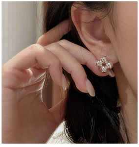 Macro shot of silver S925 four-leaf clover stud earrings with spherical metal beads