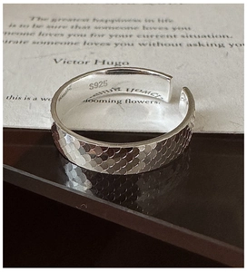 Détail macro d'une bague en argent sterling S925 avec anneau ajustable et texture écaille
