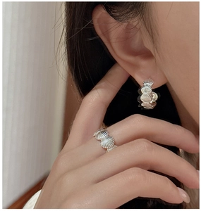 Detailed macro view of S925 silver shell-textured ring and matching earring set