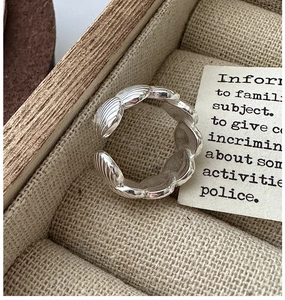 Detailed macro view of S925 silver shell texture open ring on a vintage linen jewelry box