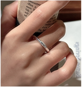 Detail of S925 sterling silver ring featuring irregular hammered texture on index finger