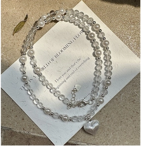 Détail du collier de perles en argent S925 avec cristaux blancs et pendentif cœur mat