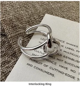 Macro shot of S925 sterling silver knotted cross ring on textured linen and paper
