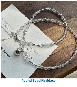 Detail of S925 silver beaded necklace with clear crystals and a small bell pendant