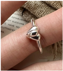 Macro shot of minimalist S925 sterling silver ring with double heart layered design
