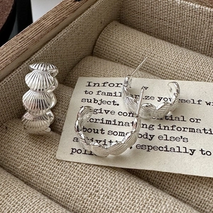 Retro S925 sterling silver shell earrings with vintage striped design on linen background