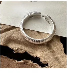 Détail macro d'une bague ouverte en argent S925 mat à texture verticale de style rétro