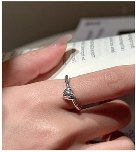 Close-up of polished S925 sterling silver ring with overlapping heart design on finger