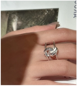 Detailed view of an S925 sterling silver knotted ring on finger with a vintage design