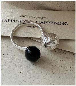 Détail macro d'une bague en argent 925 avec perle facettée et agate noire lisse